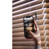 Smartelefon som skanner en QR-kode på en brun persienne