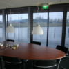 Multifilm-gardin på et møterom med det ovalt møtebord