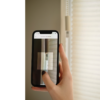 Smarttelefon skanner koden på en plisségardin med MotionBlinds-styring